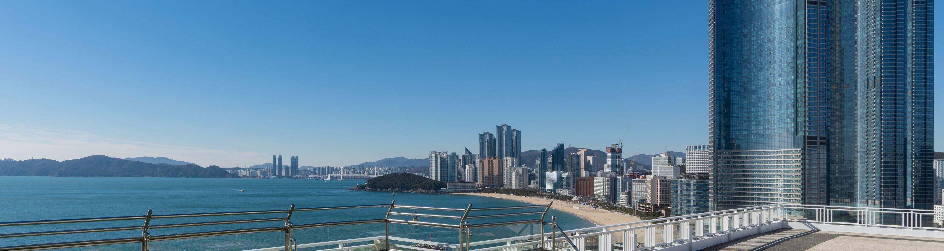 Amusez-vous en famille, en couple ou entre amis dans un bain de pieds extérieur avec une vue imprenable sur la plage de Haeundae et le pont Gwangan.